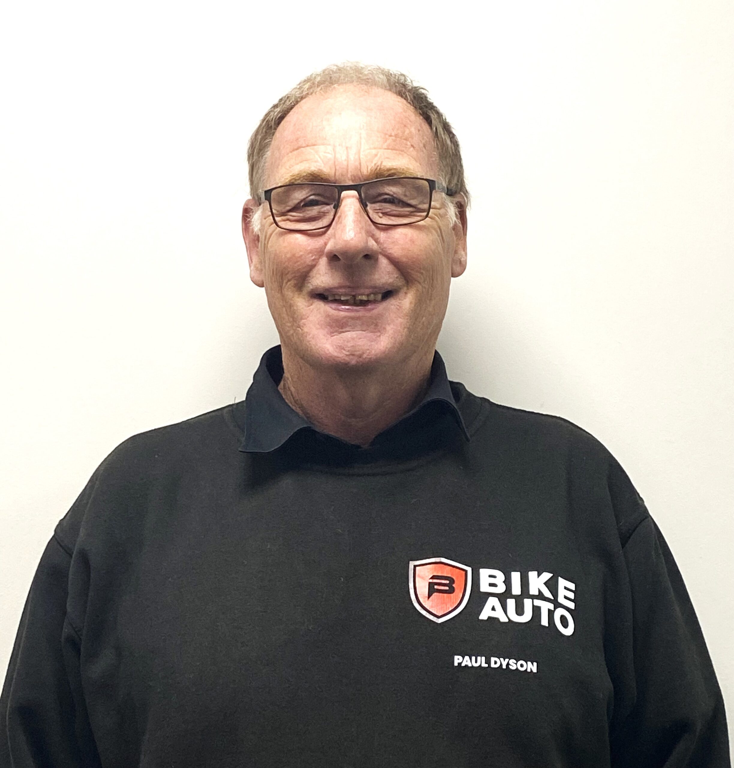 Photo of owner, Paul Dyson, in branded Bike Auto workwear.
