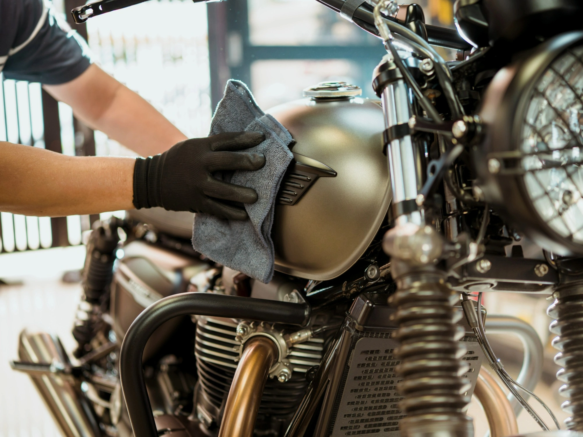 A gold coloured motorbike being professionally detailed.